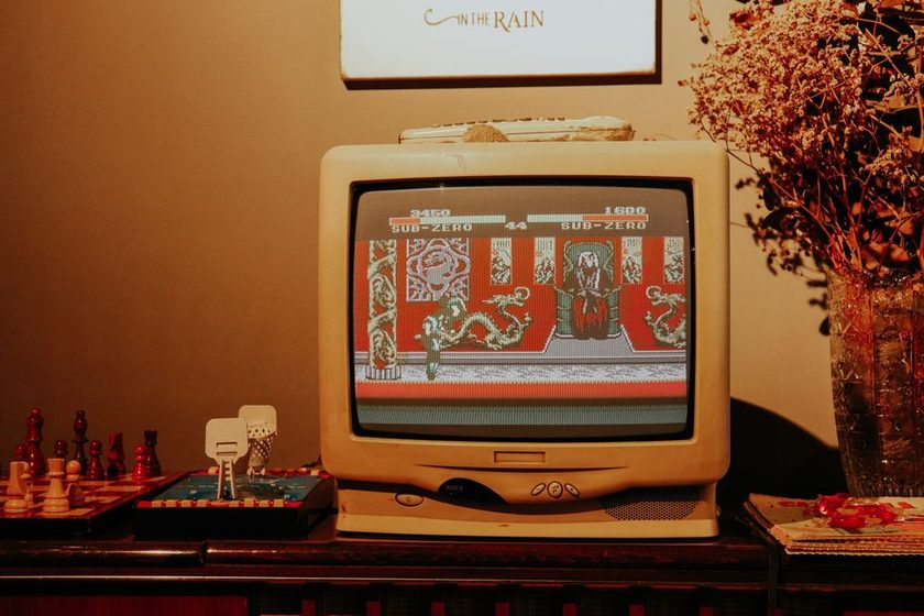 Console retro conectado a televisão de tubo em sala de estar, ambiente doméstico brasileiro